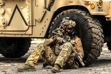 A group of military men in combat gear patrol in the middle of a desert and tropical jungle. Soldiers in full combat gear in dry weather conditions assemble and march on a mission.