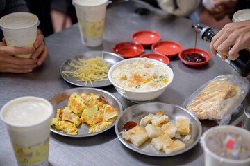 Traditional Taiwanese breakfast spread featuring congee, radish cakes, scallion pancakes, and soy milk. Authentic local flavors are perfect for food and culture themes.