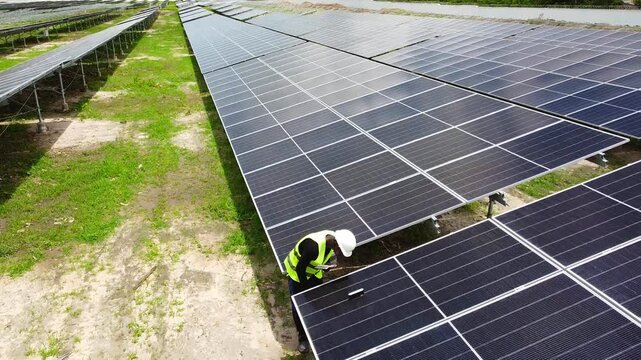 Aerial view of professional quality management engineer taking solar panel tilt angle measurements at NAWEC TBEA solar power plant in Jambur - Gambia
