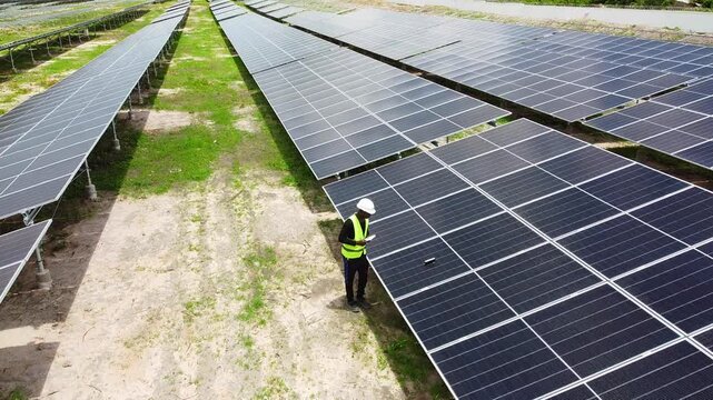 Aerial view of engineer taking new solar panel tilt angle measurements at NAWEC TBEA solar power plant in Jambur - Gambia