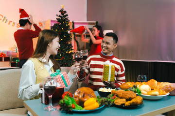 Drinks and conversation, at Merry Christmas and  New Year. Friends are happy and celebrating with food, wine and friendship of love and gift exchange at the event.