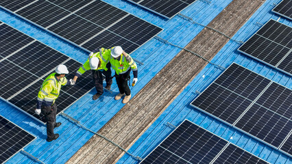 Worker Technicians are working to construct solar panels system on roof. Installing solar photovoltaic panel system. Men technicians walking on roof structure to check photovoltaic solar modules.