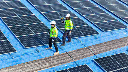 Worker Technicians are working to construct solar panels system on roof. Installing solar photovoltaic panel system. Men technicians walking on roof structure to check photovoltaic solar modules.