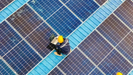 Worker Technicians are working to construct solar panels system on roof. Installing solar photovoltaic panel system. Men technicians walking on roof structure to check photovoltaic solar modules.