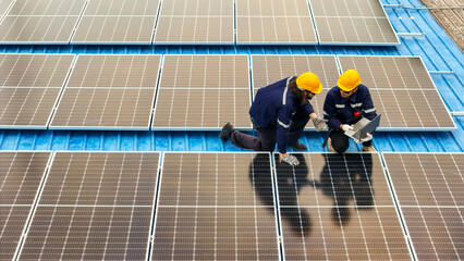 Photovoltaic engineers work on roof top warehouse. workers Inspect and repair the solar panel...
