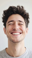 Fototapeta premium An attractive smiling man with his face distorted into the shape of a large, exaggerated smile.
