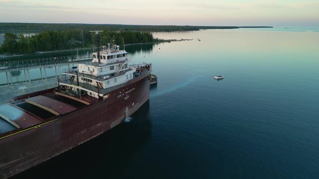 Aerial orbit view of great lakes freighter bow on flat water, lake huron