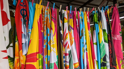 Close up of colourful cultural Polynesian pareo patterned fabrics hanging on a line on tropical island of Mo'orea in French Polynesia, South Pacific