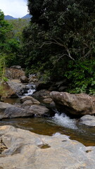 Fototapeta premium Clear River Flowing Between Rocks in a Scenic Landscape