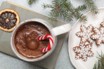 Cozy winter lifestyle concept. Mug of hot drink with vintage book and tasty homemade Christmas gingerbread cookies.	