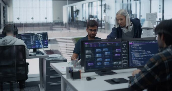 Two Diverse Multiethnic Colleagues Having a Conversation while Busy Working on a Team Project. Female Manager Talking with an Indian Programmer. Teamwork in Technological Office