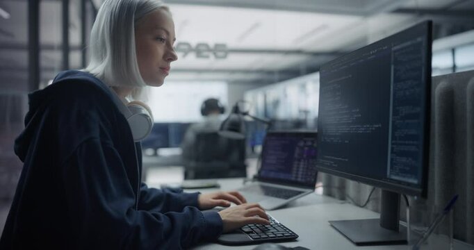 Focused Young Caucasian Female Collaborate on a Project with an Innovative Team of Developers in a Modern Glass Office. Colleagues Creating Digital Solutions in a Creative Corporate Environment