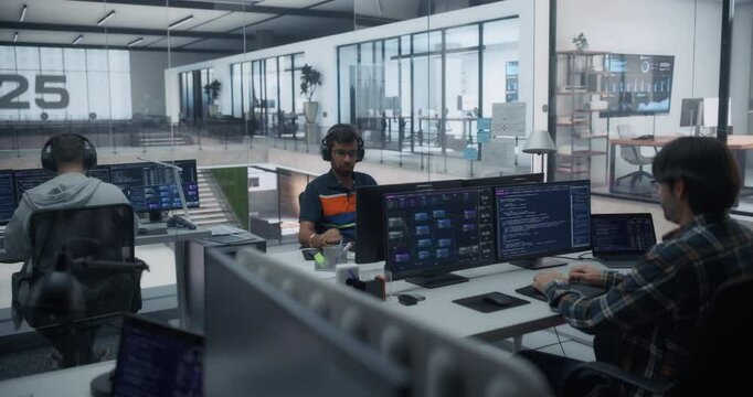 Three Male Software Developers Working in a Modern Glass Office, Using Computers for Reviewing Lines of Code and Testing Artificial Intelligence Models to Drive Innovation in Their Project