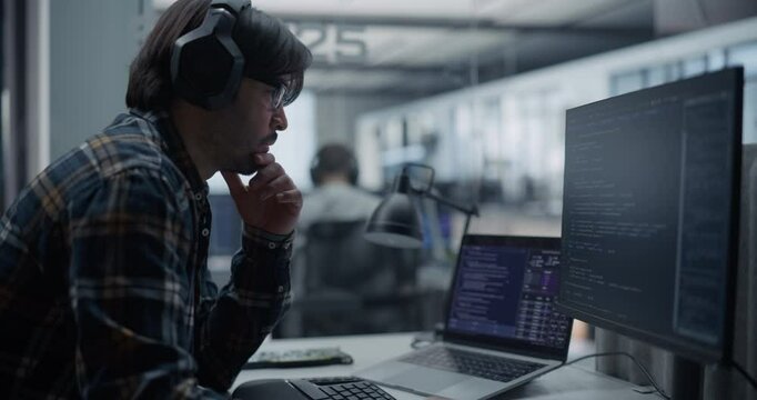 Portrait of a Thoughtful Engineer Working on Computer in a Technological Corporate Agency. Hispanic Man Writing Software Code for an Innovative Artificial Intelligence Online Training Model