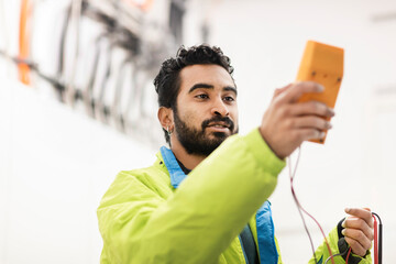 young engineer with beard checking with a device