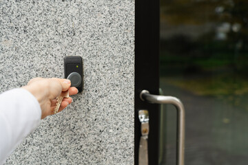 Woman's hand opening entrance door with fob