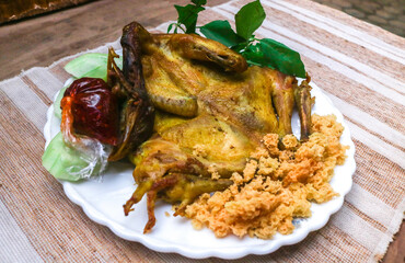 whole fried chicken with a sprinkling of Indonesian kremes. Served with shrimp paste chili sauce and fresh green vegetables