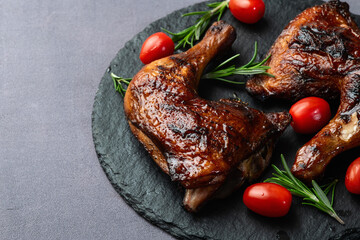 Grilled chicken legs with tomatoes and salad . Top view