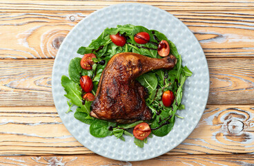 Grilled chicken legs with tomatoes and salad . Top view