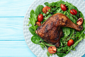 Grilled chicken legs with tomatoes and salad . Top view