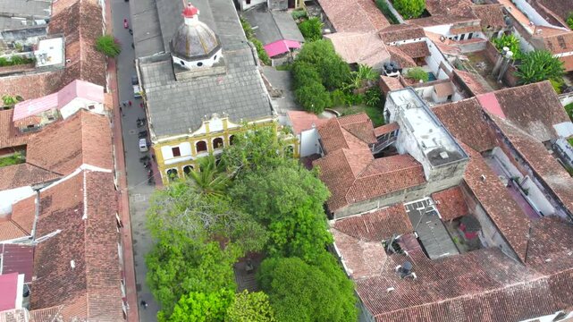The drone glides above the rooftops in the heart of Mompox, revealing the intricate colonial architecture that defines this historic town. Pitch forward with jaw left.