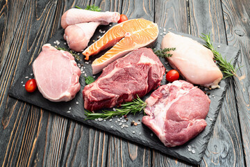 Mix of raw meat and fish . Salmon , beef , pork , chicken staek . Top view