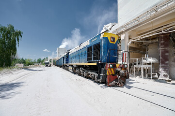 Shunting diesel locomotive moves cars at silica factory