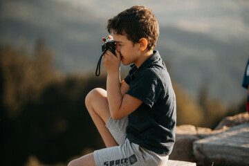 Child taking a photo outdoors, capturing a moment of creativity and exploration in nature