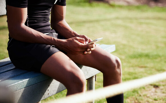 Rugby, hands and man with phone for sports results, competition and texting on bench to relax at field. Fitness, athlete and player on mobile app for game, social media and check score on internet - Powered by Adobe