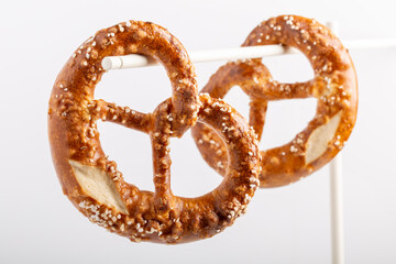 Two soft pretzel with salt on white background.