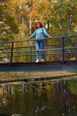 Redhead lady standing on a bridge in a park