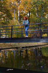 Redhead lady standing on a bridge in a park