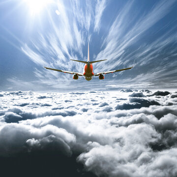 Rear view of an aircraft flying above the clouds