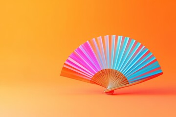 A colorful fan is on a bright orange background