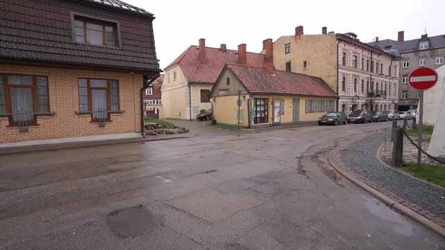 Cesis, Latvia - November 13, 2024 - Quiet, small-town street scene with historic buildings, cobblestone pavement, and a &ldquo;no entry&rdquo; sign on a cloudy day.
