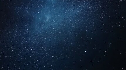 Obraz premium A dark blue night sky filled with many stars and a few clouds.