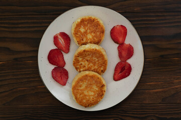 Homemade Syrniki with Strawberries on Rustic Table