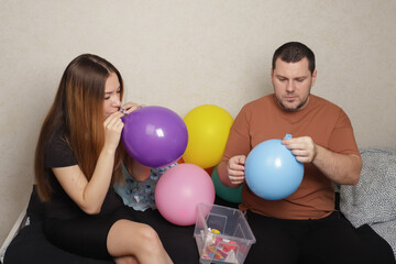 Father and daughter Blowing Up Balloons for Party Decoration, celebrating a family event with colorful decorations, happiness in inflating balloons and ribbons.