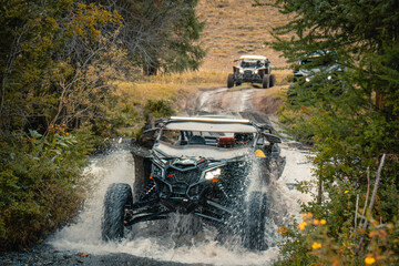 Buggy trip in a Altai desert. Mountain landscape with hills and beautiful blue sky with clouds in background. Off-road vehicles driving on a dust dirt road. Active leisure in Altai Republic. © VaLife