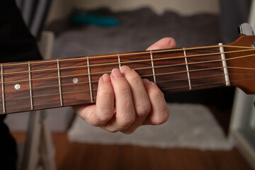 Hand Playing Acoustic Guitar Close-Up, performer strumming strings, indoor music performance