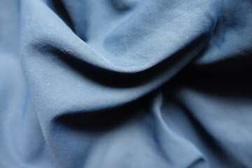 Folded thin unprinted dark blue polyester fabric