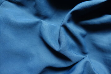 Wrinkled thin unprinted dark blue polyester fabric