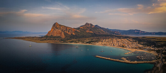Panoramic photo of San Vito Lo Capo a small seaside resort in Sicily. Famous for its beach overlooking a bay dominated from above by Monte Monaco. Crystal clear sea. Aerial drone shot, June 2023