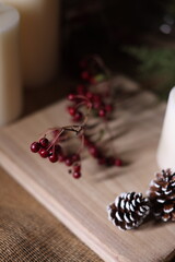 White candles with holiday greenery, creating a festive and peaceful winter ambiance