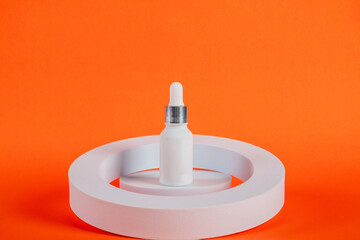 Plastic white tube for cream or lotion. Skin care or sunscreen cosmetic with stylish props on orange background 