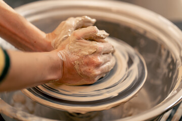 close up the clay modeling studio young girl hands giving shape to clay on a potter's wheel applied art clayware old craftsmanship