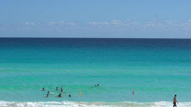 People parasailing, swimming and tanning on Cancun beach