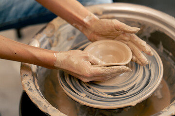 close up the clay modeling studio young girl hands giving shape to clay on a potter's wheel applied art clayware old craftsmanship teacher helps
