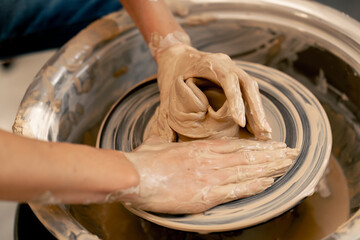close up the clay modeling studio young girl hands giving shape to clay on a potter's wheel applied art clayware old craftsmanship teacher helps