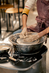 the clay modeling studio young girl hands giving shape to clay on a potter's wheel applied art clayware old craftsmanship